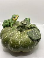 Top view of green ceramic gourd with one detailed frog sitting on top, showing textured patterns and leaf design
