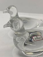 Pair of clear crystal birds with Baccarat label visible on one bird.