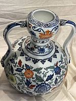 Front angle showing colorful floral designs and one handle