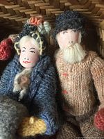 Close-up of handmade wool figurines showing painted faces and knitted wool clothing details