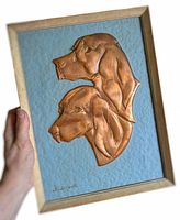 Frontal view of the copper dog relief art held in hand showing artist signature and some perspective on size.