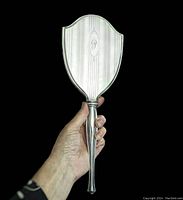 Front side of the sterling silver hand mirror held in hand showing size and shape