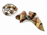 Two vintage gold filled brooches: one a multi-tone gold bow with rhinestones, the other a round floral and vine brooch.
