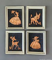 Four wood-framed copper relief art pieces displayed together, showing their relative size and condition.