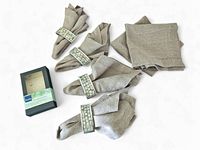 Napkin rings with taupe linen napkins, some napkins folded through rings, napkins loose and flat to side, original Denby box present