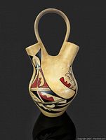 Front view of the vintage Hopi wedding vase showing two spouts, curved handle, and black and red geometric painted designs.