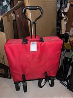 Red collapsible folding outdoor utility wagon cart with black handle in folded position