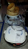 Image showing wooden pasta bowls stacked inside larger wooden salad bowls, with Pyrex Cornflower casserole dish topped with clear lid in front.