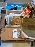 Box containing assorted vintage maps, postcards, ephemera, including Texaco Road Map of Pennsylvania, and Kellogg's Tony the Tiger advertising hat cutout visible on top right.
