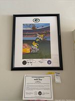 Framed print on wall with certificate and lot tag below