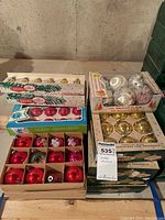 Top-level photo showing an assortment of Shiny Brite Christmas glass ornaments in original boxes, includes red, pink, silver, and gold bell-shaped ornaments.