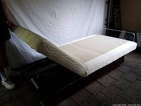 Single twin adjustable base showing foam top and metal frame, head section raised