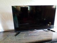 Front view of Toshiba 32 inch flat-screen TV showing the screen and stand legs.