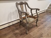 Front and left side view of an antique wooden armchair with original blue paint and missing seat showing frame.
