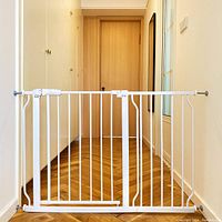 White metal safety gate installed in a doorway for display, showing the vertical bars and walk-thru door with latch.