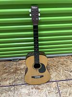 Full front view of Hohner parlor guitar showing body, neck, and headstock with tuning pegs but missing nut.