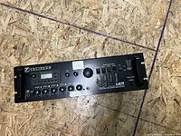 Front panel of Yorkville Coliseum amplifier showing control knobs, input selectors, and LCD screen.