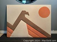 Full view of the Ron Brejtfus ultra suede textile artwork showing the full eagle and sun design with a cream background and geometric shapes in brown and orange tones.