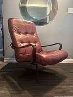 Front three-quarter view showing seat cushion, tufting, armrests and overall form