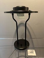 Photo of the lamp unlit showing the base, dual legs, and flying saucer top with translucent panels beneath.