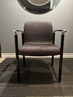 Front view of the Herman Miller EL101 armchair showing chrome frame and dark fabric seat and back