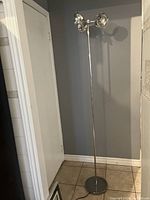 Full view of the vintage IKEA Klimat floor lamp showing its tall chrome pole, round base and three lamp heads positioned at the top.