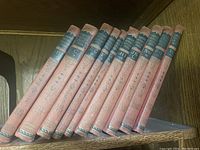 Ten volumes of Compton’s Pictured Encyclopedia arranged side by side showing spines with alphabetic labels.