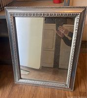 Front view of the rectangular silver framed mirror with decorative beading on the frame.