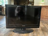 Front view of Samsung 25 inch TV with black frame and oval base stand.