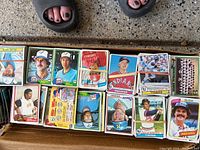 Stack of late 1970s baseball cards featuring players from Cleveland Indians, Minnesota Twins, Detroit Tigers, and others, with visible player portraits and some cards showing backs with advertisements.