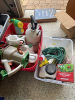 Photo showing various gardening and outdoor items including sprayers, garden hose, beetle bags and small bottles