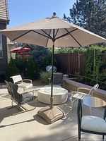 Straight center-pole beige umbrella deployed over patio seating
