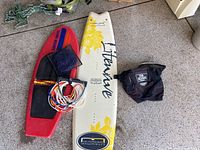 Full view of the water sports equipment including kiteboard, knee board, harness, ropes and handle.
