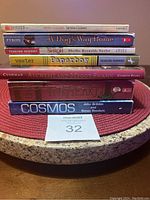 South side view showing nine assorted books stacked, titles mostly legible, including Henry Huggins, A Dog's Way Home, Shiloh, Paperboy, Alchemist and Maggy Swann, TimeLapse, and Cosmos.