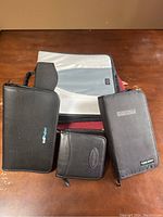Top view of five CD/DVD cases, including one large gray case, two medium black zip cases, and two smaller black cases.