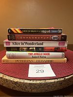 Stack of 6 classic children’s books including Alice in Wonderland, The Jungle Book, Peter Pan, and a French edition of Harry Potter.