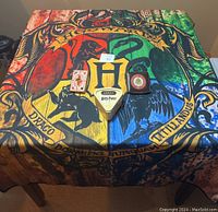 Photo showing a large Harry Potter Hogwarts houses blanket as a table cover with three Harry Potter-themed games arranged on it.