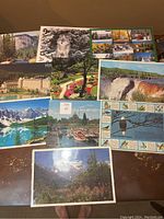 Top view of nine placemats spread out, showing a variety of nature scenes including an owl, mountain lake, waterfall, and birds.