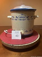 Full view of Rival Crock-Pot slow cooker showing beige speckled body with blue floral pattern, side handles, dial, and power cord.