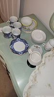 Various china pieces including teacups, plates, and Limoges platter shown together on a table
