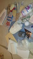 Overview of assorted sewing supplies including stuffing bags, pattern cardboard pieces, and fabric pieces.