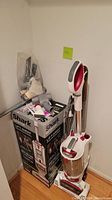 Upright vacuum assembled next to original Shark Rotator Lift-Away Professional box with attachments bagged on top