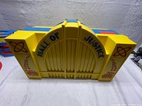 Closed facade showing yellow cast front with "Hall of Justice" lettering