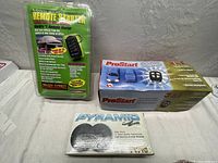 Lot display showing long range remote starter kit, ProStart remote starter kit, and a Pyramid relay switch box.