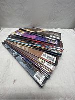 Stack of 25 assorted comics with visible spines and backs showing