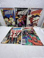 Lot of 5 Daredevil comic books arranged side by side on a table showing full covers.