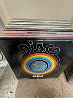 Top view of a stack of vinyl record albums including the Disco RCA compilation cover at front.