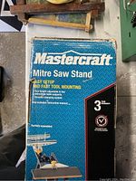 Photo of the front of the Mastercraft Mitre Saw Stand box showing branding, product name, features and warranty information.