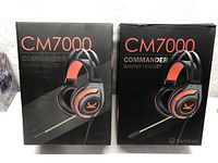 Two sealed retail boxes of Vankyo CM7000 Commander gaming headsets side by side.