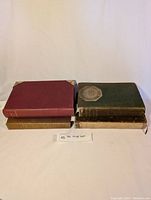 Four books arranged in two stacks showing clothbound and paperbound volumes